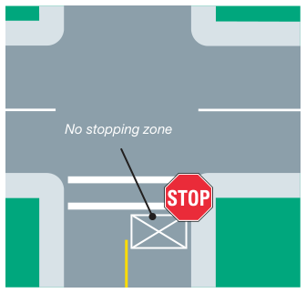 An intersection with a marked no-stopping zone shown as a crossed box on the roadway.